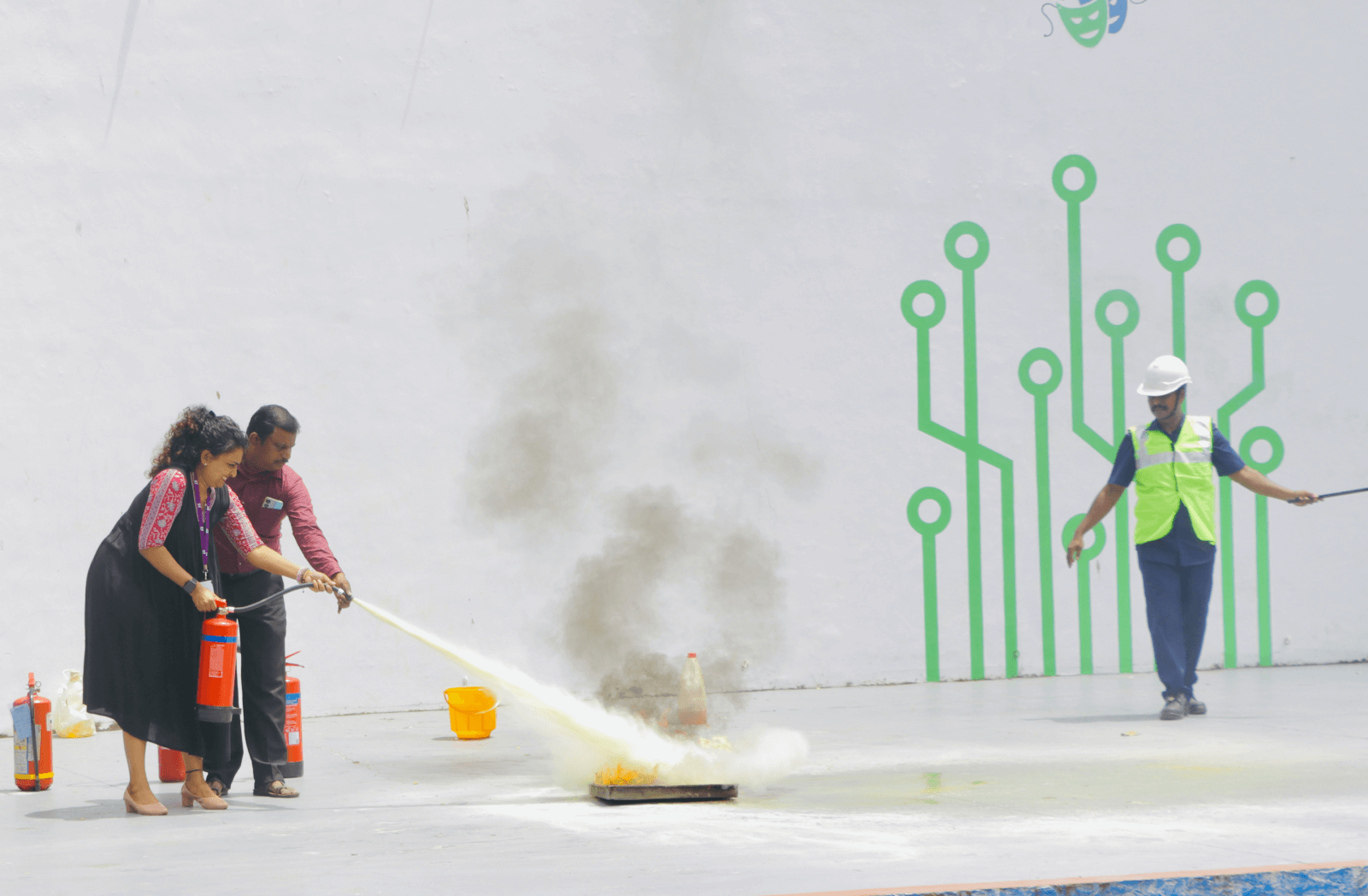 A member of the Technopark Fire & Safety team helping an employee put out a fire.